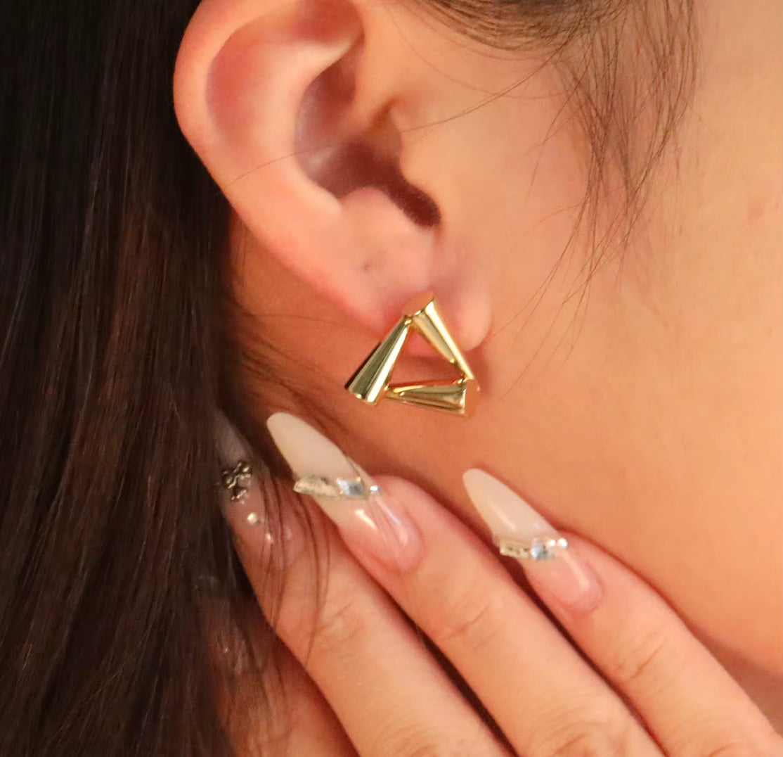 Close-up of waterproof gold triangle earrings with eco-friendly plating, designed for sensitive ears