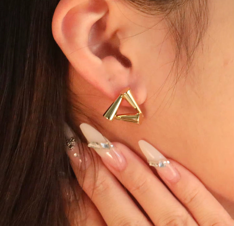 Close-up of waterproof gold triangle earrings with eco-friendly plating, designed for sensitive ears