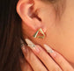 Close-up of waterproof gold triangle earrings with eco-friendly plating, designed for sensitive ears
