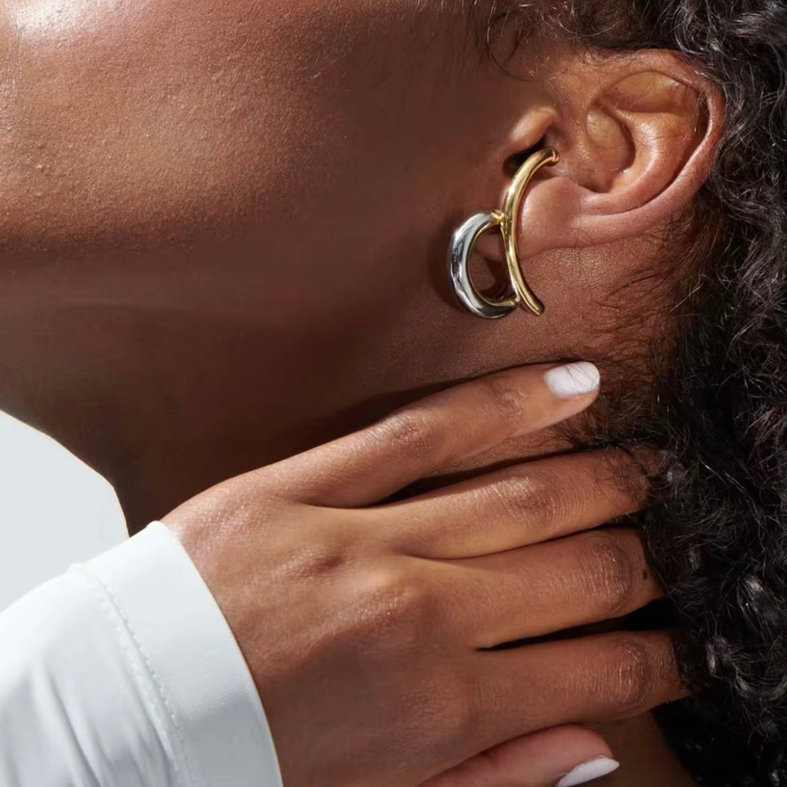 Close-up of woman wearing bold gold and silver Zaria statement hoop earrings by ELSSIZ