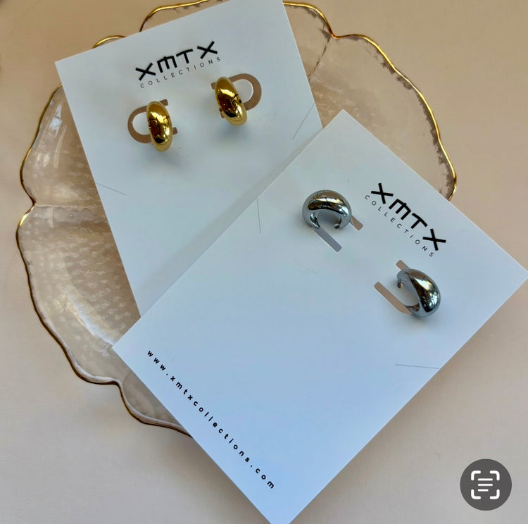 Gold and silver earrings on ELSSIZ Collection cards with a beige background