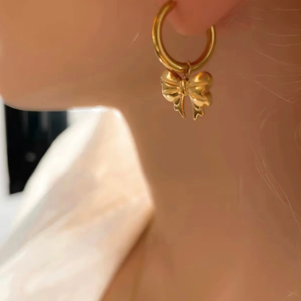 Embrace the latest trend with our must-have Bow Huggies Earrings. These cute accessories add a touch of charm to any outfit. Expertly crafted and designed to hug the ear, they are the perfect addition to your jewelry collection.

Made to last!&nbsp;Tarnish and Water Resistant, Beach &amp; Shower friendly, Hypoallergenic

.82" total length from the hoop the the tip of the bow

18K Gold Plated over 316L Stainless Steel base