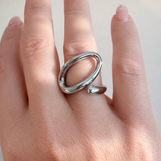 Silver open-end statement ring with oval loop design worn on hand, made of polished stainless steel, non-tarnish and waterproof by ELSSIZ