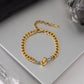 Gold and silver two tone curb chain bracelet on neutral surface modern waterproof jewelry