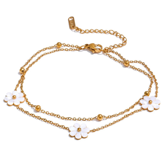 Add a touch of whimsy to your outfit with our Mother of Pearl Flowers Anklet. Delicate and dainty, this anklet features pretty, natural shell flowers that will elevate any look. Perfect for those who want to add a fun and playful touch to their style.

&nbsp;

This piece is made to last, hypoallergenic anti tarnish &amp; water resistant&nbsp;

316L Stainless Steel 18K Gold Plated

8.5 inches long +2 inches ext