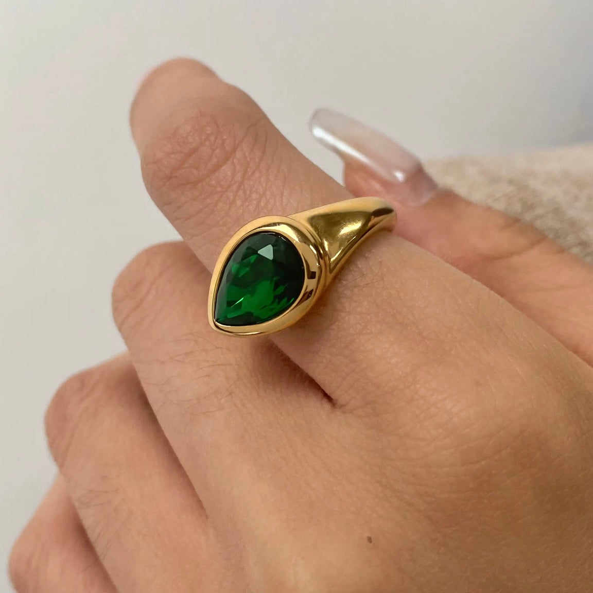 Expertly designed, the Ivy Ring features a stunning tear-shaped deep green gemstone that adds a modern statement to any ensemble. Crafted with precision and style, this accessory exudes elegance and sophistication, making it a must-have for any fashion-forward individual.&nbsp;

Green Zircon

Stainless Steel 18K Gold PVD Plated - Made to last!

Hypoallergenic, Tarnish free Beach &amp; Pool Friendly
