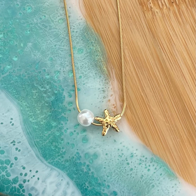 ntroducing the Isla Star &amp; Pearl Necklace, a stunning addition to our Under the Sea Collection. Beautiful and beach ready, this necklace is made to withstand water without tarnishing. Keep it on all summer long without worry.




Made to last!&nbsp;Tarnish and Water Resistant, Hypoallergenic

16" long +2" ext

Closure : Lobster Clasp