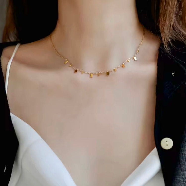 young girl wearing dainty necklace with little rectangle charms
