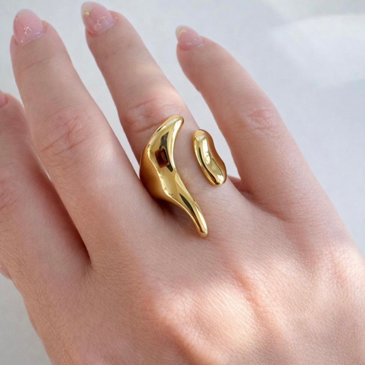 Gold open-end statement ring with organic molten design worn on hand, made of polished stainless steel, non-tarnish and waterproof by ELSSIZ