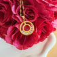 Stephanie gold circle pendant necklace with cubic zirconia detail styled on red flowers